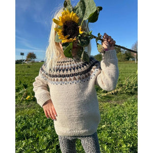 A young girl joyfully holds a vibrant sunflower, showcasing her connection to nature and the beauty of childhood.