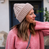 model featuring a knitted hat and a pink sweater