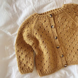 A summer cardigan with a delicate lace design and front holes, crafted from the top down for a stylish fit.