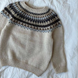 The Celeste Sweater displays a blue and white pattern, crafted with a circular yoke and finished with ribbed edges.