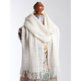 A fringed white scarf, highlighting its delicate texture and versatility as a fashionable accessory for any outfit.