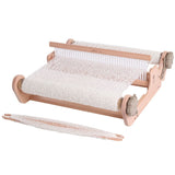 A wooden weaving machine with white yarn, part of a complete kit for creating a luxurious Merino shawl.