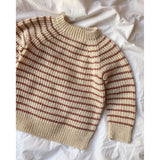 A red and white striped sweater featuring a ribbed neck, cuffs, and hem, designed with a top-down broken rib pattern.