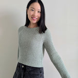 smiling women wearing the duna sweater in a mint colourway