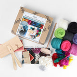 A beginner spinning kit featuring yarn, needles, scissors, and a wooden box, along with tools and instructions for spinning.