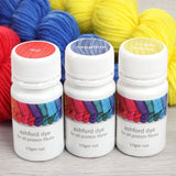  Three bottles of yarn in red, sapphire, and bright yellow, alongside a bottle of dye for creating vibrant colors.