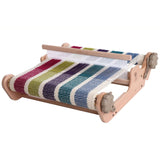A vibrant, multi-colored loom on a wooden table, perfect for sampling yarns and suitable for weavers of all skill levels.